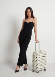 Small polka dot suitcase on wheels WALAB-0074-0P-19(W26), diagonal view of the product next to the model's silhouette.