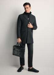 Black leather men's briefcase TORMS-0415A-99(Z25) - diagonal view of the product, held by the model, against a white background. Full body visible.