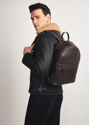 Dark brown leather men's backpack TORMS-0458-89(Z25), diagonal view of the product on the model, half of the silhouette visible.