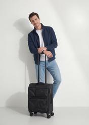 Small suitcase on wheels WALNY-0048-99-19(W26), diagonal view of the product next to the model's silhouette.