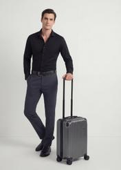 Small suitcase on wheels WALAB-0073-9C-19(W26), diagonal view of the product next to the model's silhouette.