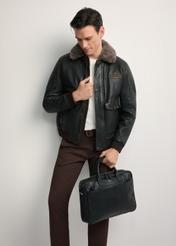 Black leather men's bag TORMS-0299A-99(Z25) - diagonal view of the product, held by the model, against a white background. Full body visible.