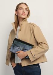 Black women's messenger bag TOREC-1167-9F(W26) - front view of the product, held by the model, against a light background. Half of the silhouette is visible.