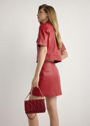 Small quilted women's handbag in red TOREC-1150-4B(W26), front view of the product on a model, half of the silhouette visible.