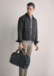 Black men's nylon bag TORMN-0420-99(W26), product view in model's hand, against a light background. Half of the silhouette visible.