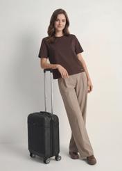 Small suitcase on wheels WALAB-0040-99-19(W25), product view diagonally next to the model, the entire silhouette is visible.