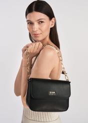 Black women's messenger bag with chain TOREC-0767C-99(Z25) - product view on a model on a white background. Half of the silhouette visible.