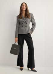Elegant graphite women's backpack TOREC-1281-9D(Z26), diagonal view of the product on a model. Full silhouette visible.