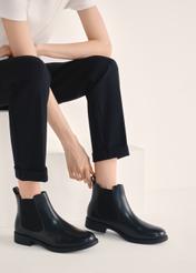Women's black leather short Chelsea boots BUTYD-1116-99(Z25), product view on the model's feet against a light background.