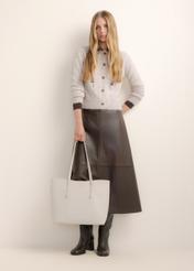 Large cream women's shopper bag TOREC-1309-0B(Z26), front view of the product, on a model, on a light background. The entire silhouette is visible.