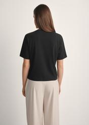Women's cotton black T-shirt TSHDT-0138-99(W25), product view from the back on the model, half of the silhouette visible.