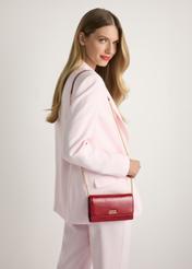 Rote Lederclutch TORES-1215-4B(W26), Vorderansicht des Produkts an einem Model, die Hälfte der Silhouette ist sichtbar.