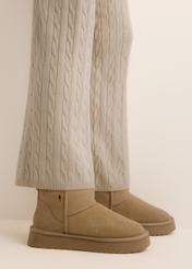 Beige short women's snow boots (BUTYD-1138-1K(Z26)), side view on a model's feet, against a light background.