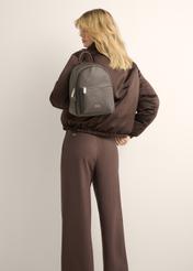 Dark brown women's backpack TOREC-0996-1H(Z26), front view of the product on a model. Half of the silhouette visible.