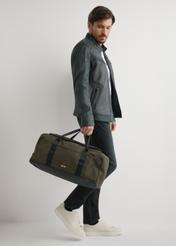 Khaki travel bag TORMN-0417-8D(W26) - front view of the product, held by the model, against a light background.