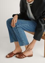 Women's leather mules in cognac color BUTYD-1266-1F(W26), side view of the product on the model's feet, on a light background.