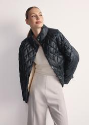 Black women's quilted jacket KURDT-0597-98(Z25), front view of the product on the model, half of the silhouette visible.-02