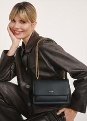 Black women's handbag on a chain TOREC-1100-99(Z25), front view of the product on the model's shoulder. Half of the silhouette visible.