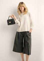 Small black monogrammed trunk bag TOREC-1292-9P(Z26), view of the product in the model's hand. Half of the silhouette visible.
