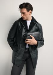 Men's leather cosmetic bag with logo TORMS-0298A-99(Z25) - diagonal view of the product, held by the model, against a white background. Knee-length silhouette visible.