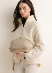 Beige women's cosmetic bag TOREC-1348-1B(Z26), front view of the product on a model. Half-body shot.