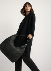 Black leather woven handbag TORES-1242-9P(W26), product view in model's hand. Half of silhouette visible.