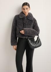 Black women's hobo bag with jewelry accent TOREC-1326-99(Z26), diagonal view of the product on a model. Half of the silhouette visible.