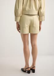 Light yellow women's leather shorts SPODS-0035-2A(W26), product view from the back on the model, half of the silhouette visible.