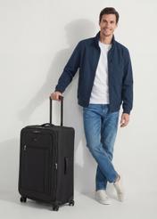 Large suitcase on wheels WALNY-0046-99-28(W26), diagonal view of the product next to the model's silhouette.