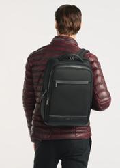 Black men's travel backpack TORMN-0376-99(Z25), front view of the product on the model, half of the silhouette visible.