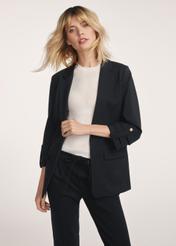 Black women's blazer without fastening ZAKDT-0034-99(Z24) - front view of the product on a model on a white background. Half of the silhouette visible.