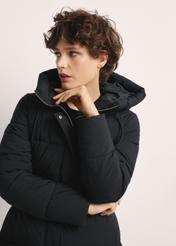 Long black women's jacket KURDT-0602-99(Z25), front view of the product on the model. Half of the silhouette visible.