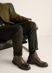 Men's brown leather ankle boots BUTYM-0569-1I(Z26) - side view of the product, on a model, against a light background. Half of the silhouette visible.