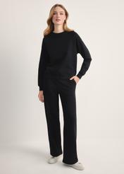 Black women's trousers SPODT-0111-99(Z25), front view of the product on the model. Full body visible.