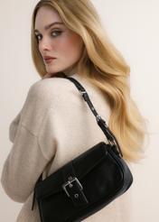 Black women's handbag with a buckle, model TOREC-1370-99(Z26); front view of the product on a model's shoulder.