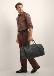 Black leather travel bag TORMS-0535-9I(Z26), front view of the product on the model. Full body visible.
