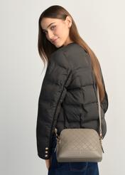 Light brown women's monogrammed handbag TOREC-1180-1K(W26), product view on model's shoulder. Half of silhouette visible.