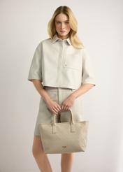 Cream women's handbag with braid TOREC-1212-0B(W26) - front view of the product, held by the model in her hand, on a light background.