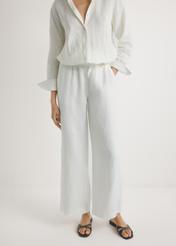 Light beige linen women's trousers SPODT-0124-1A(W26), front view of the product on the model, half of the silhouette visible.