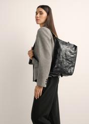 Black women's shoulder bag with stitching TOREC-1248-9P(Z26), product view on model's shoulder. Half of silhouette visible.