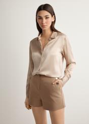 Women's elegant camel shorts SZODT-0018-1D(W26), front view of the product on the model. Half of the silhouette visible.