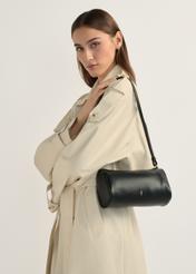 Small black women's handbag TOREC-1176-99(W26), product view on model's shoulder. Half of silhouette visible.