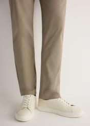 White leather sports shoes BUTYM-0503A-0B(W26), side view of the product on the model, half of the silhouette visible.