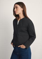 Black transitional women's nylon jacket KURDT-0656-99(W26), side view of the product on the model, half of the silhouette visible.