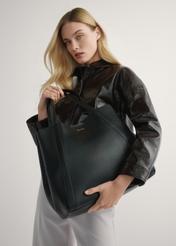 Women's black leather shopper bag TORES-1208-9I(W26) - view of the product held in the model's hand against a light background. Half of the silhouette is visible.