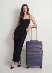 Medium suitcase on wheels WALAB-0084-7D-24(W26), front view of the product next to the model's silhouette.