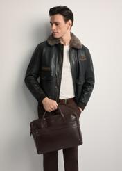 Brown leather men's bag TORMS-0460-89(Z25) - front view of the product, held by the model. Half of the silhouette visible.