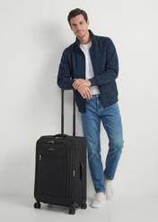 Medium suitcase on wheels WALNY-0046-99-24(W26), diagonal view of the product next to the model's silhouette.