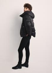 Black women's down jacket KURDT-0585-99(Z25), product visible from the side on the model, the entire silhouette is visible.
