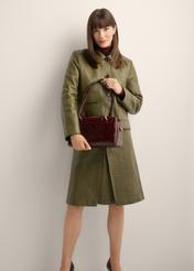 Women's burgundy leather shoulder bag TORES-1392-4E(Z26) - front view of the product, held by the model, against a light background. The entire silhouette is visible.